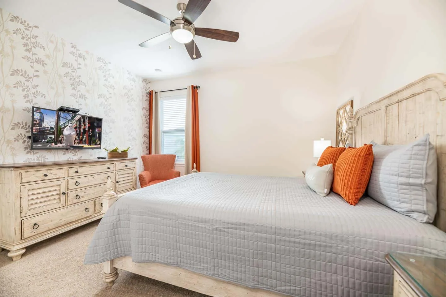 Un dormitorio con una cama grande, una cómoda y un ventilador de techo.