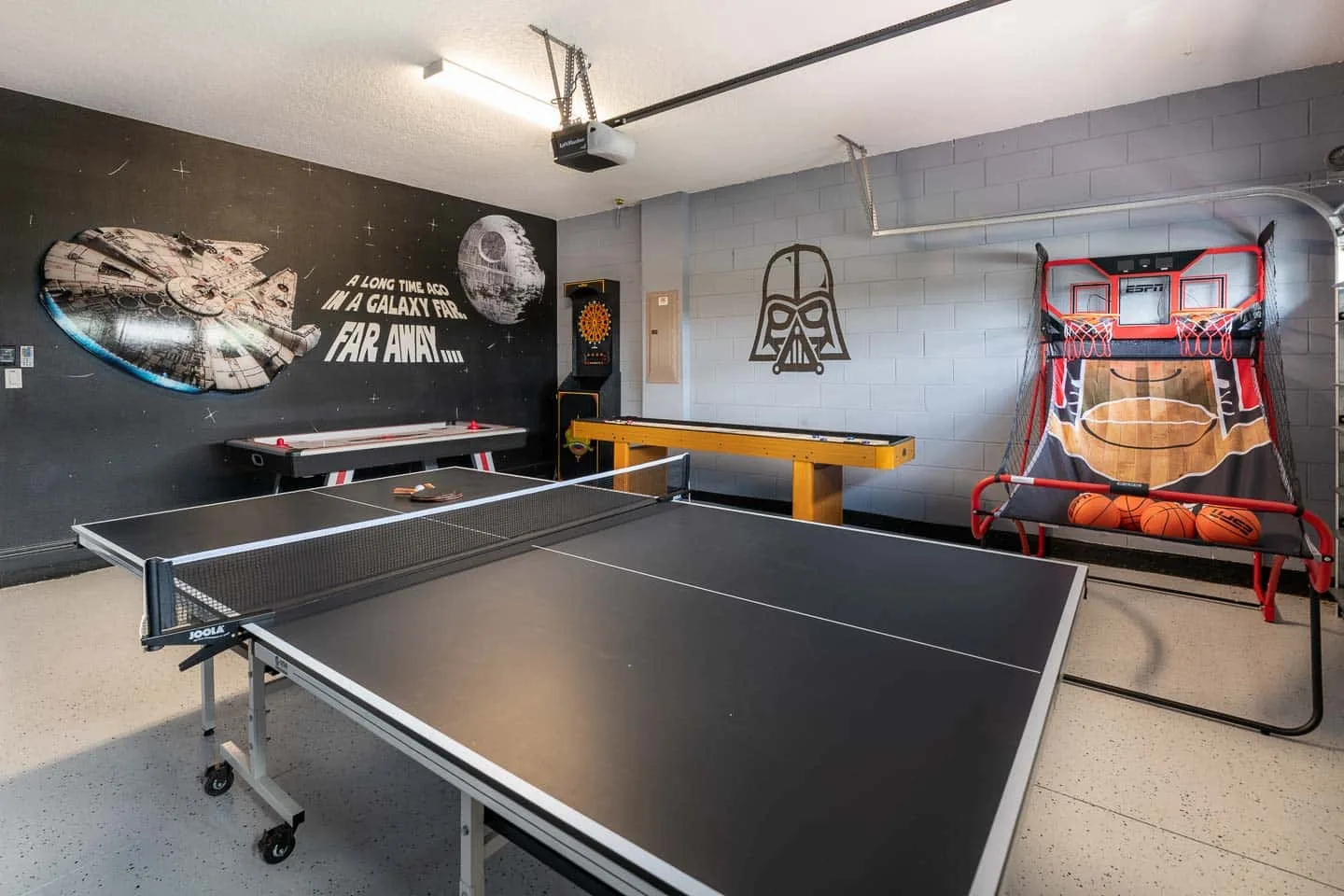 Una sala de recreación cuenta con una mesa de ping-pong, un juego arcade y una canasta de baloncesto.