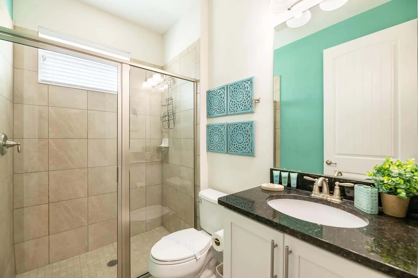 Un baño luminoso con ducha de vidrio y tocador.
