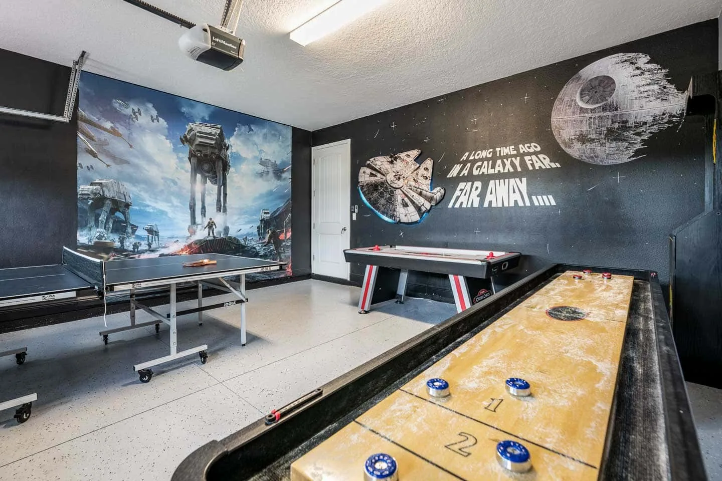 A game room features a shuffleboard table, ping-pong table, and space-themed wall art.