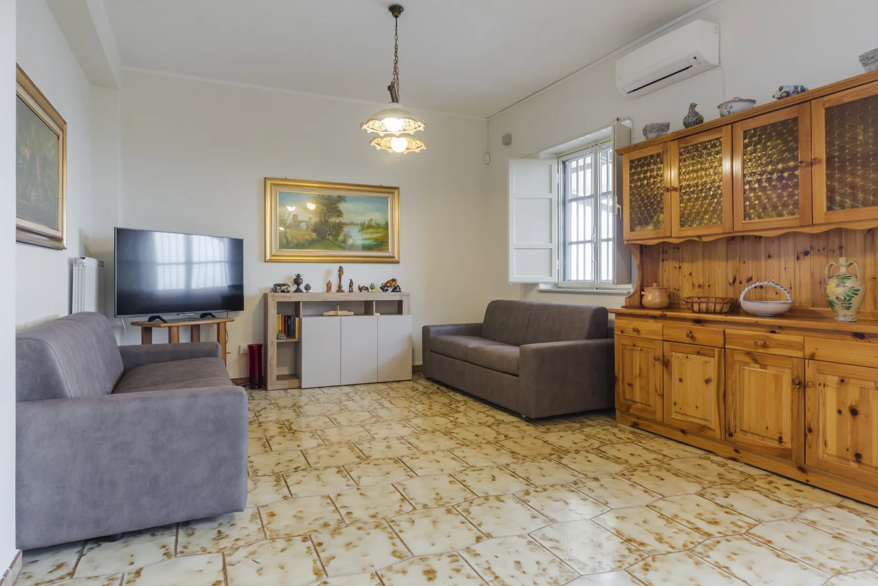 Una sala de estar con asientos, un televisor y un mueble de madera.
