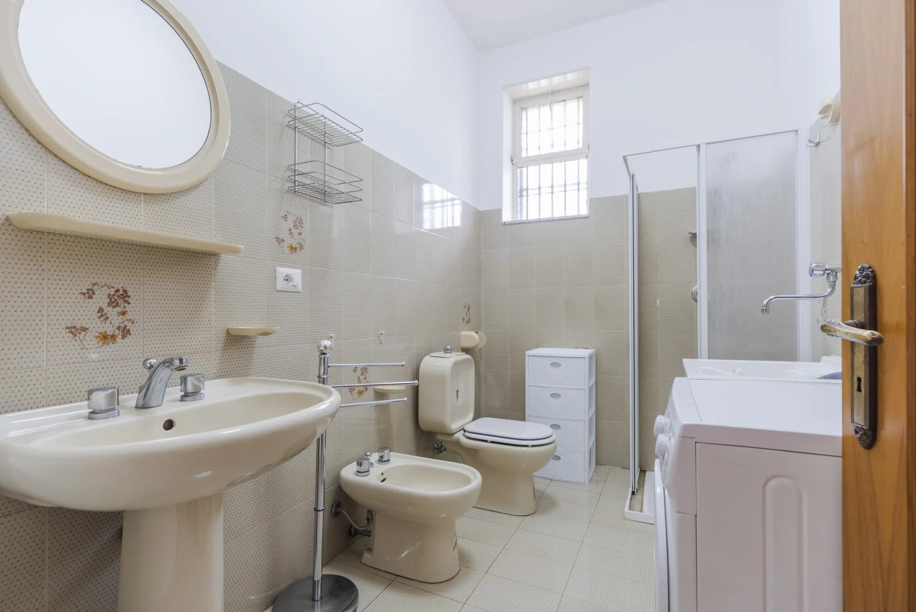 Un baño luminoso con lavabo, inodoro, bidé y ducha.