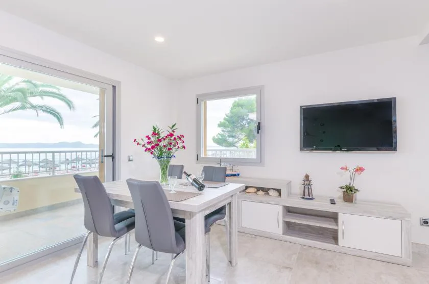 A bright dining area with a table and chairs beside a sliding glass door.