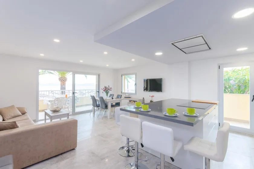 Una luminosa sala-comedor de concepto abierto con una isla de cocina y asientos.
