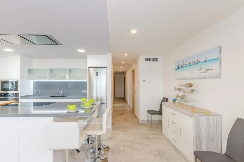 A bright open-plan kitchen and dining area opens onto a hallway.
