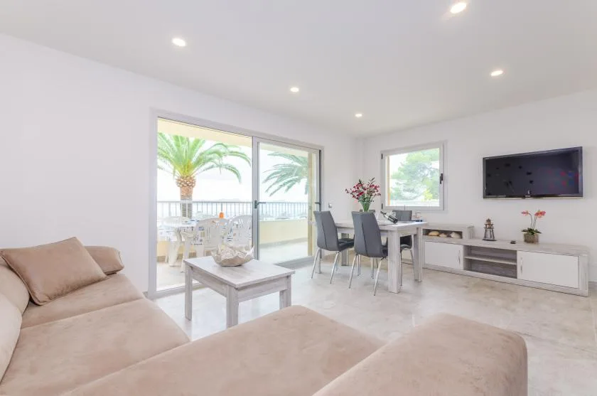 A bright living and dining area with seating, a table, and large glass doors.