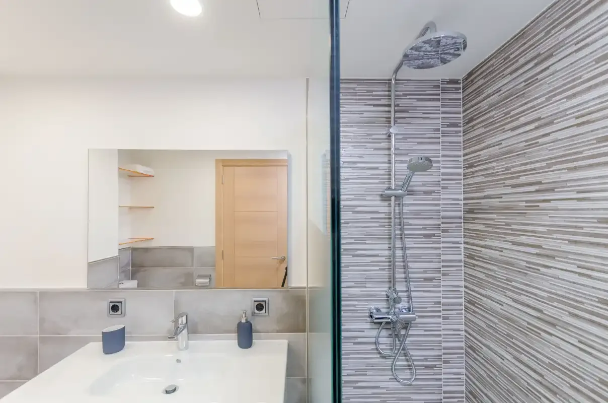 A bathroom with a sink and shower.