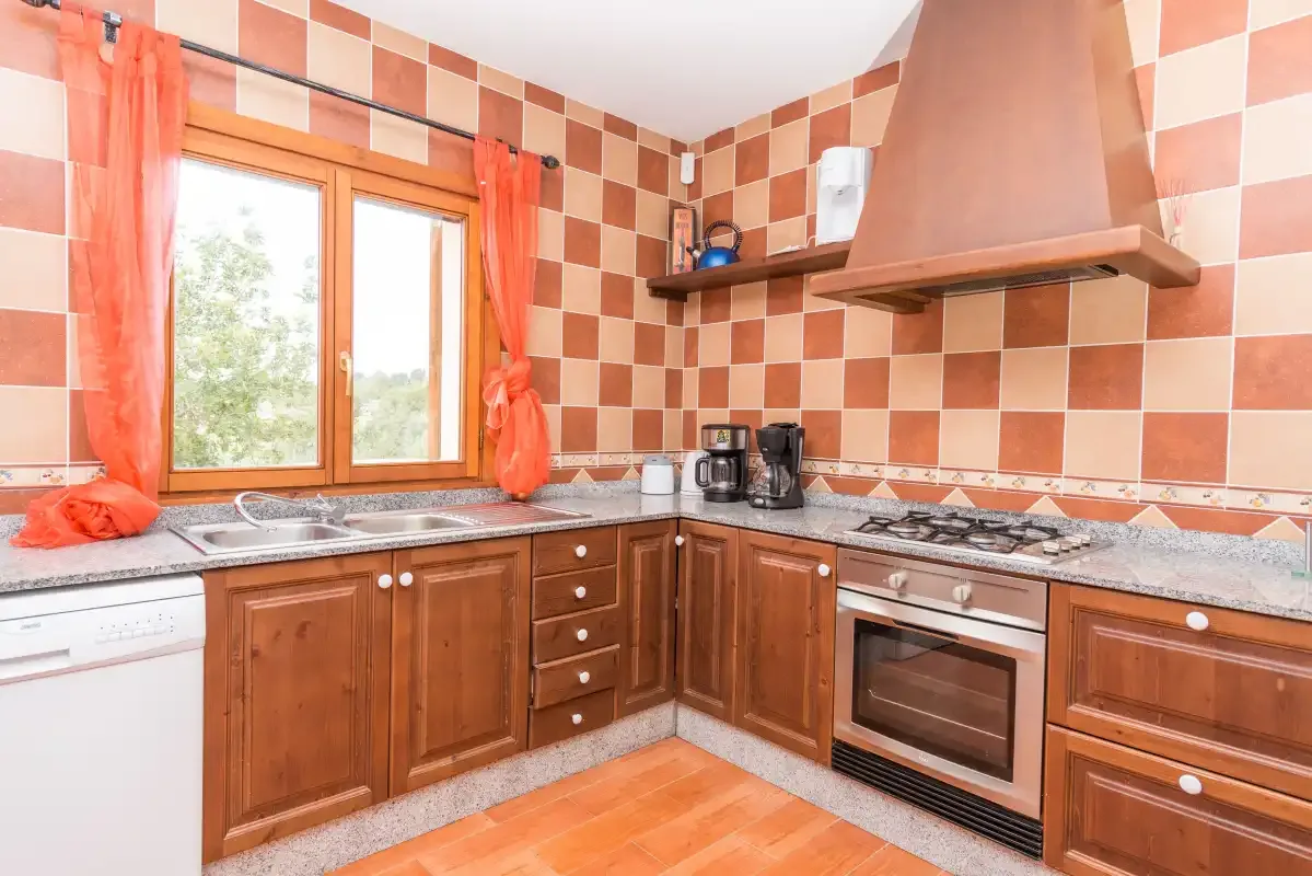 A kitchen with wooden cabinets, a tiled backsplash, and a window.
