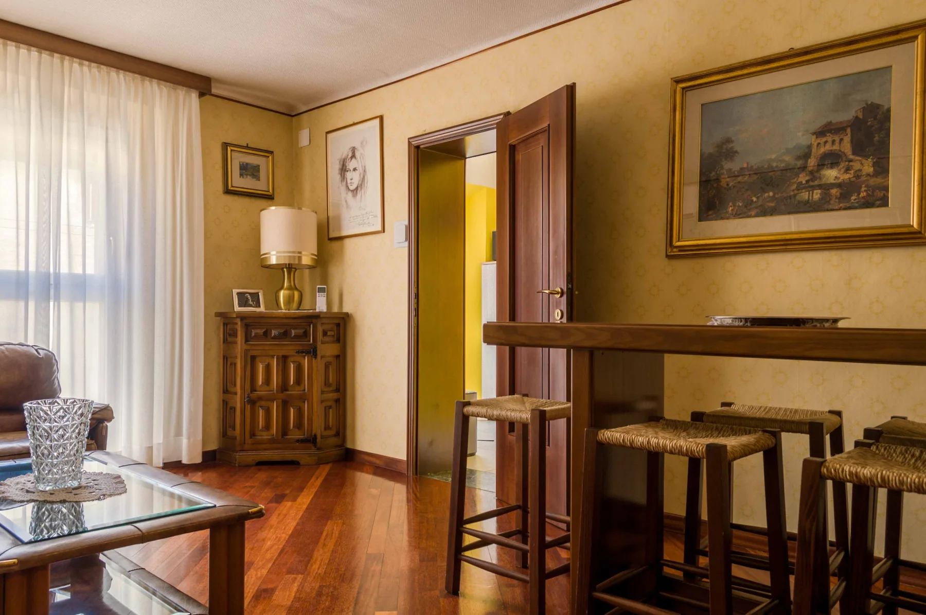 A warmly decorated living room with a wooden counter and seating.