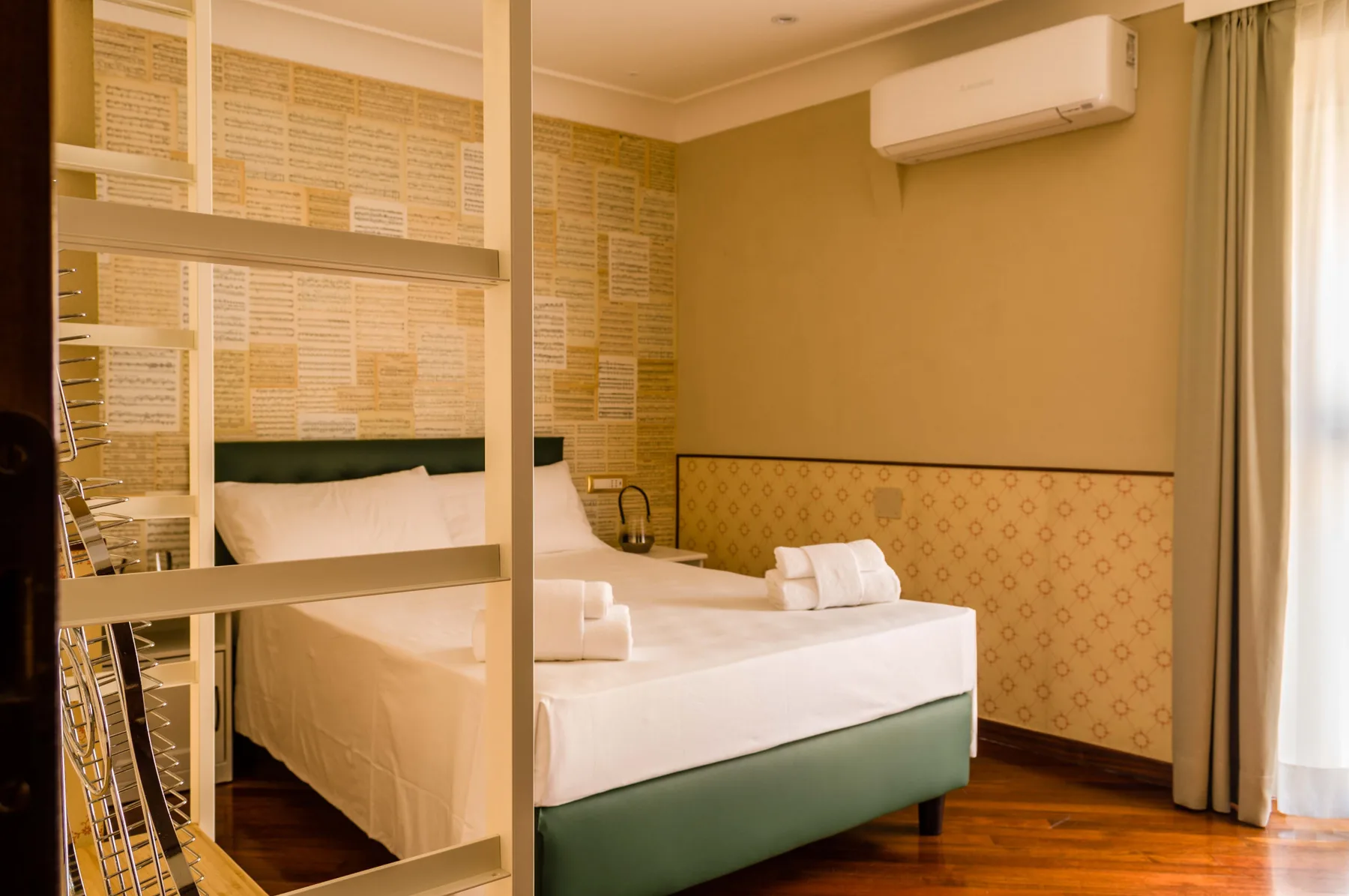 Un dormitorio con una cama bien tendida y un aire acondicionado en la pared.