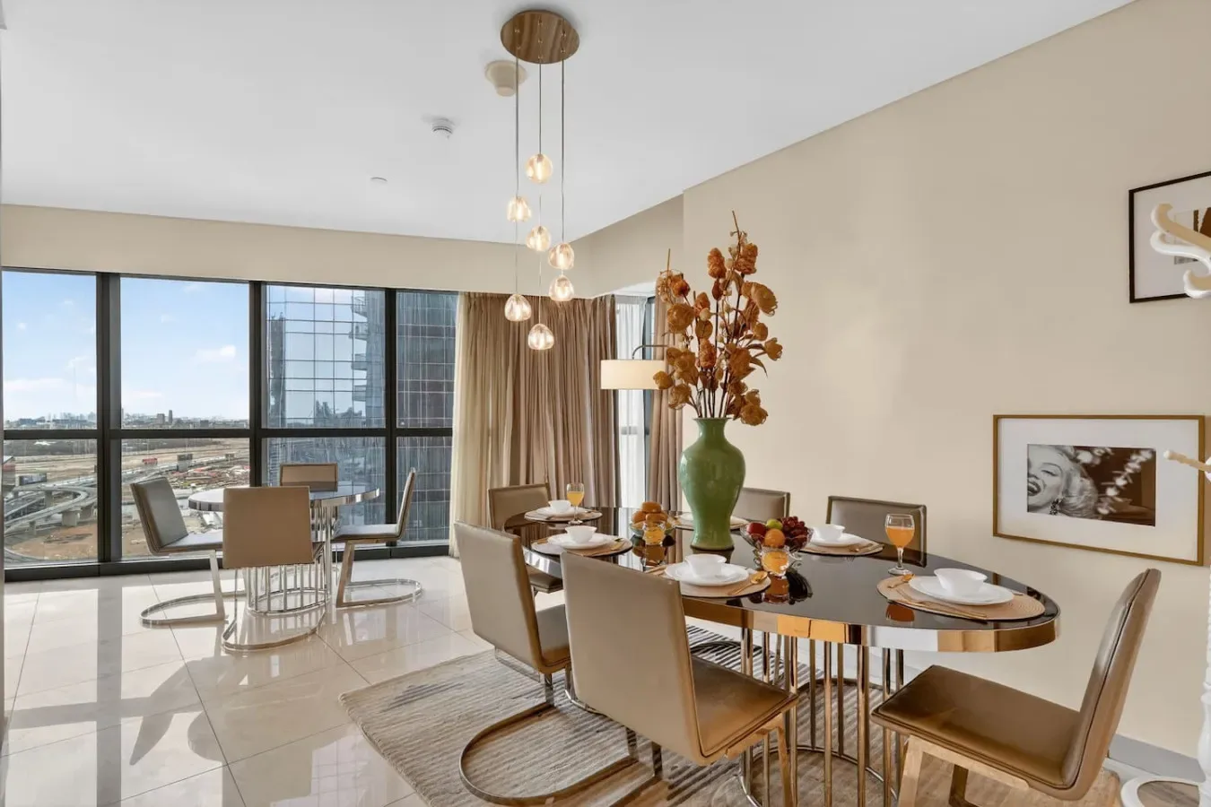 A dining area with a long table and large windows overlooking the city.