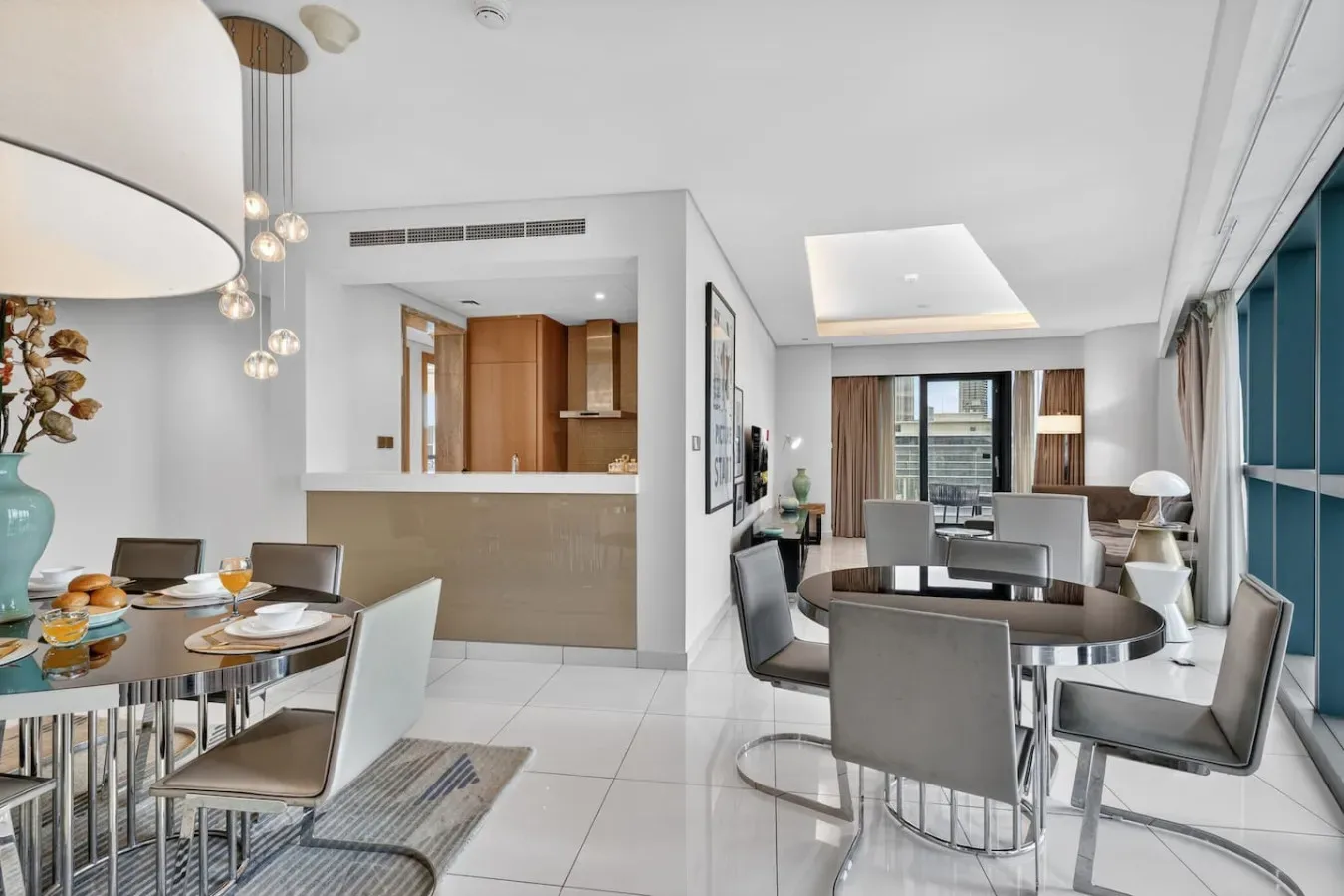 A bright open-plan dining and living area with a dining table and seating.