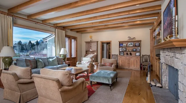 Una sala de estar con asientos alrededor de una mesa de centro junto a una chimenea.