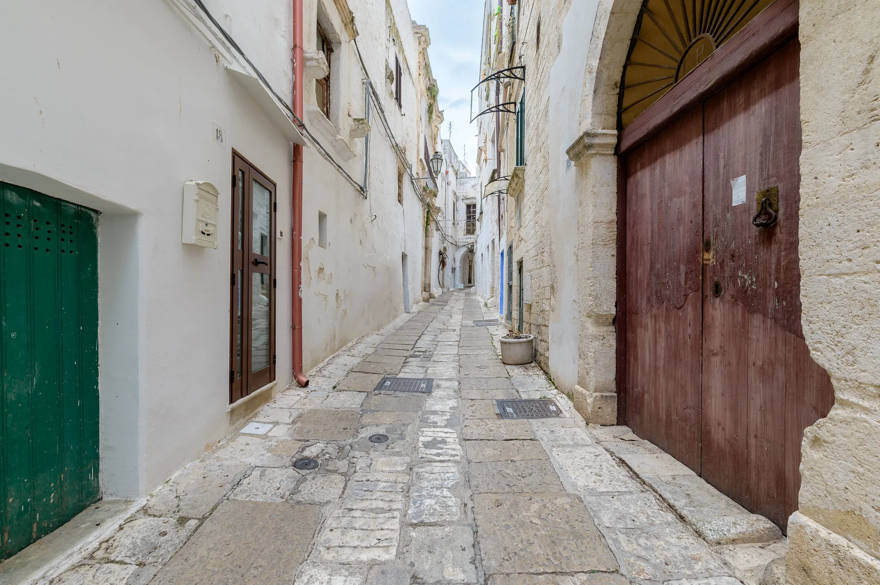 Un callejón estrecho pavimentado de piedra pasa entre edificios muy juntos.