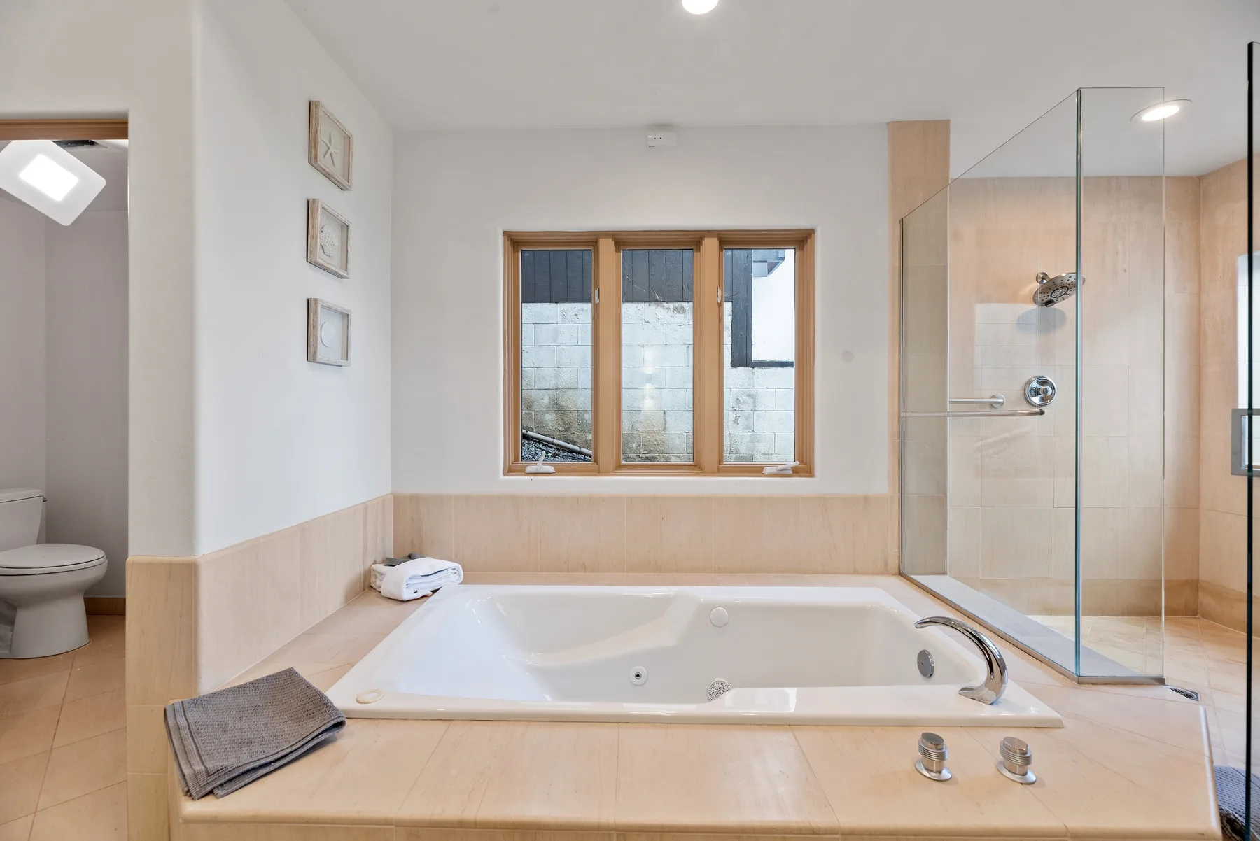 Un baño luminoso con bañera y ducha con mampara de vidrio.
