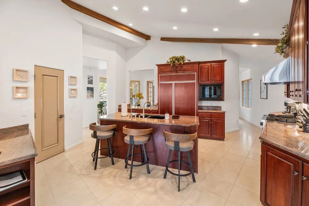 Una cocina amplia con una isla curva y gabinetes de madera.