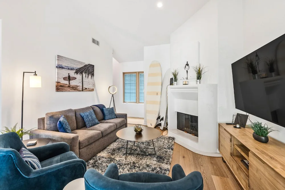 Una sala luminosa con asientos, una chimenea y un televisor.