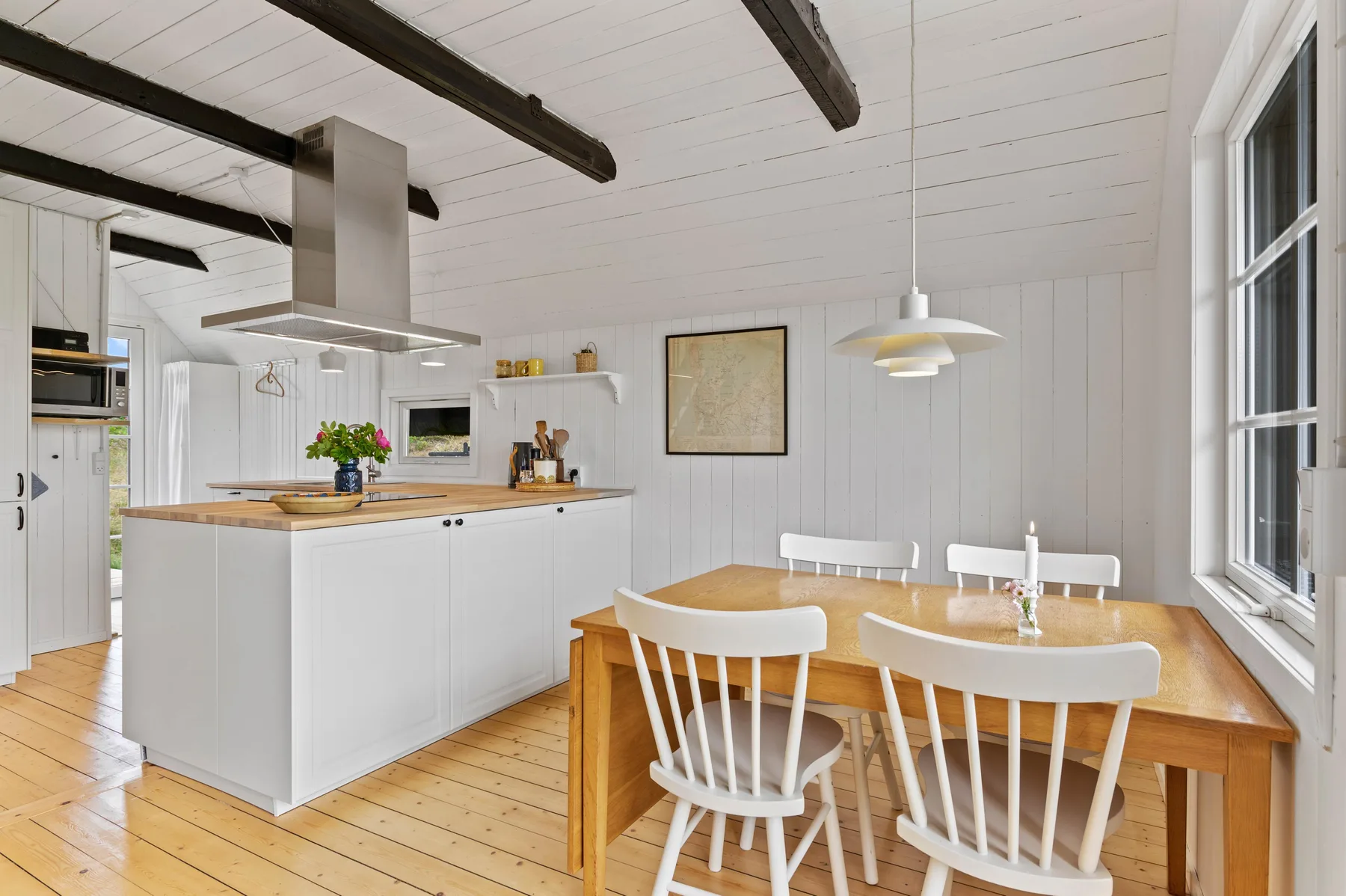 A bright kitchen and dining area with a central island and wooden table.