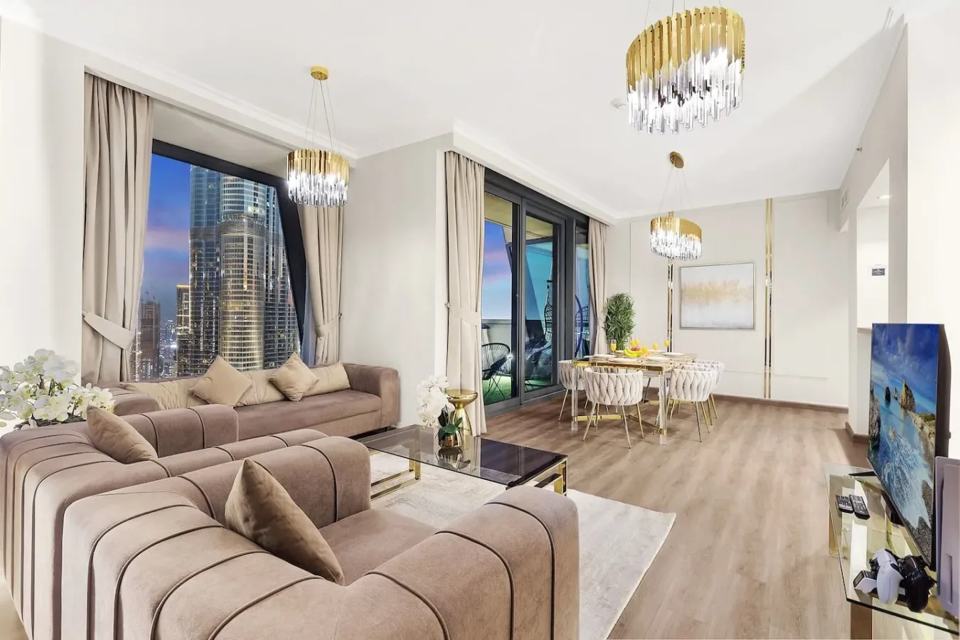 A living room with seating, a dining area, and large windows overlooking the city.