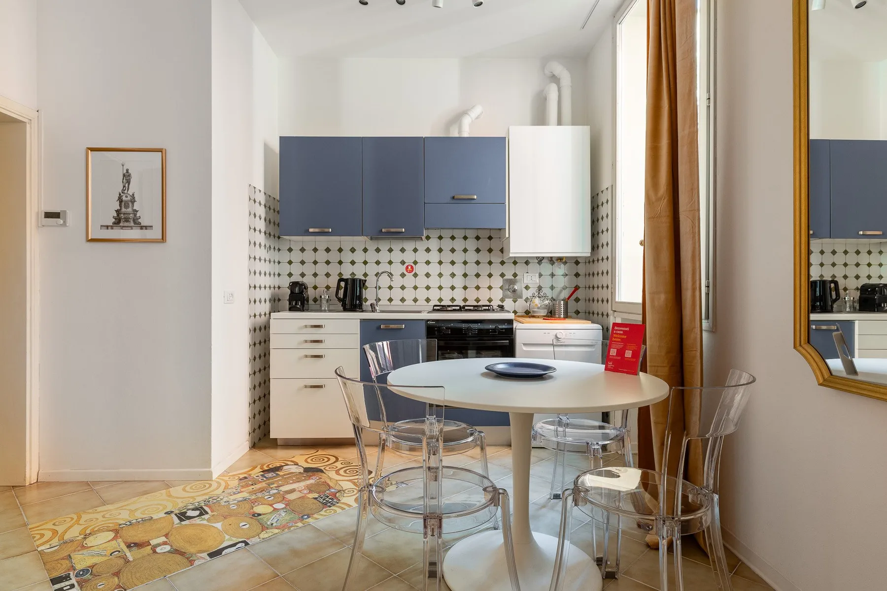 Una cocina con armarios azules y una mesa redonda con asientos transparentes.