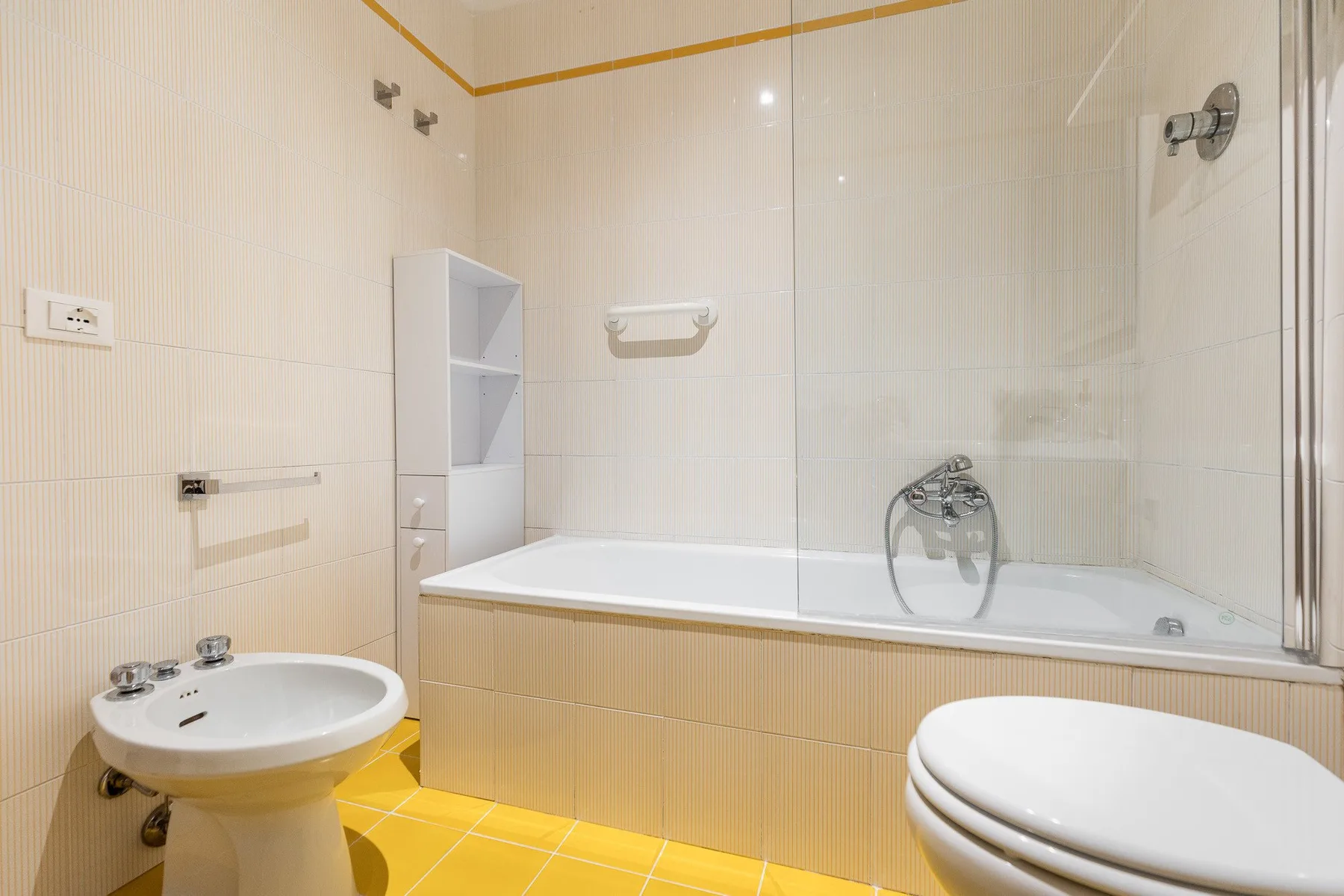 Un baño con azulejos, bañera, lavabo e inodoro.