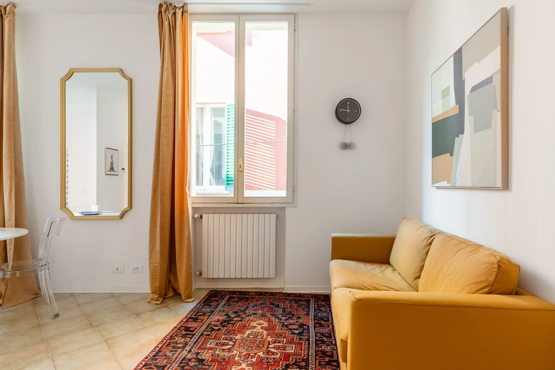 Una sala de estar con asientos amarillos, una alfombra y una ventana.