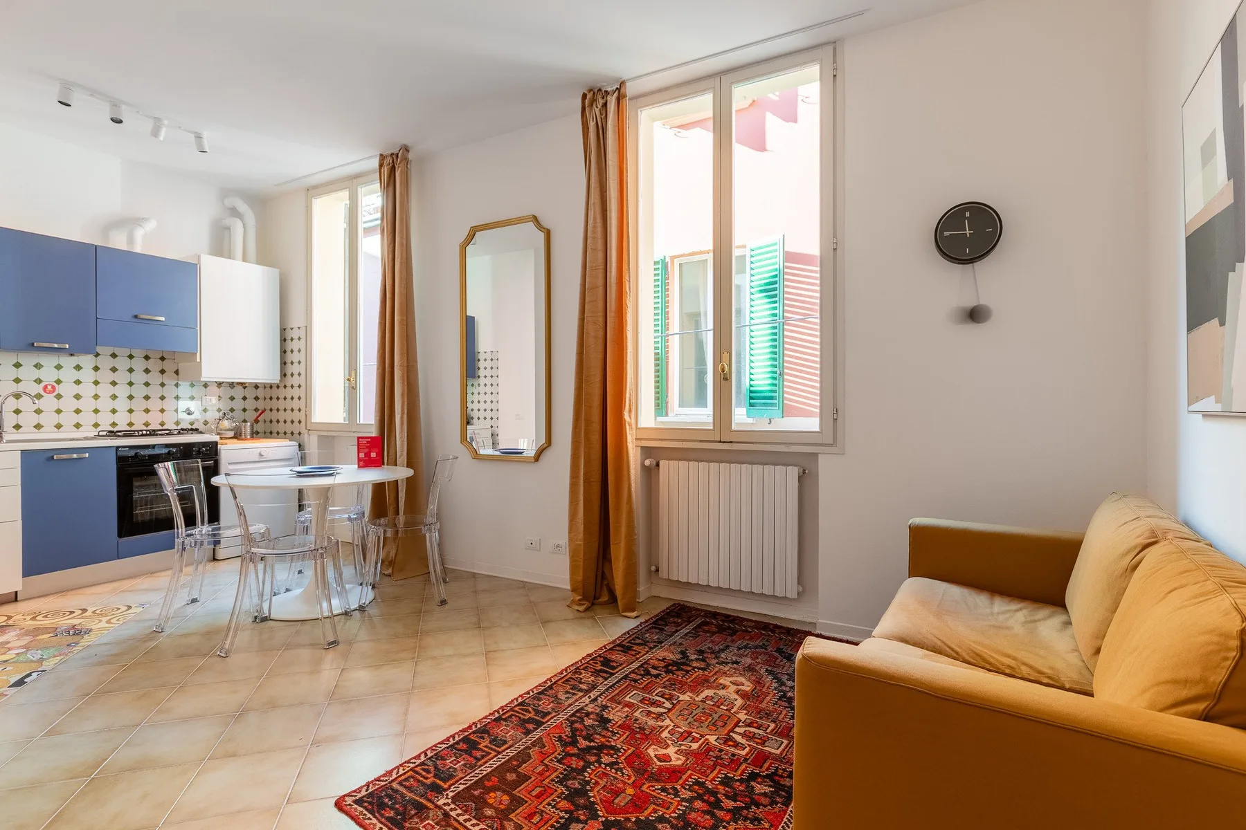 A bright living area with an open kitchen and a yellow sofa.