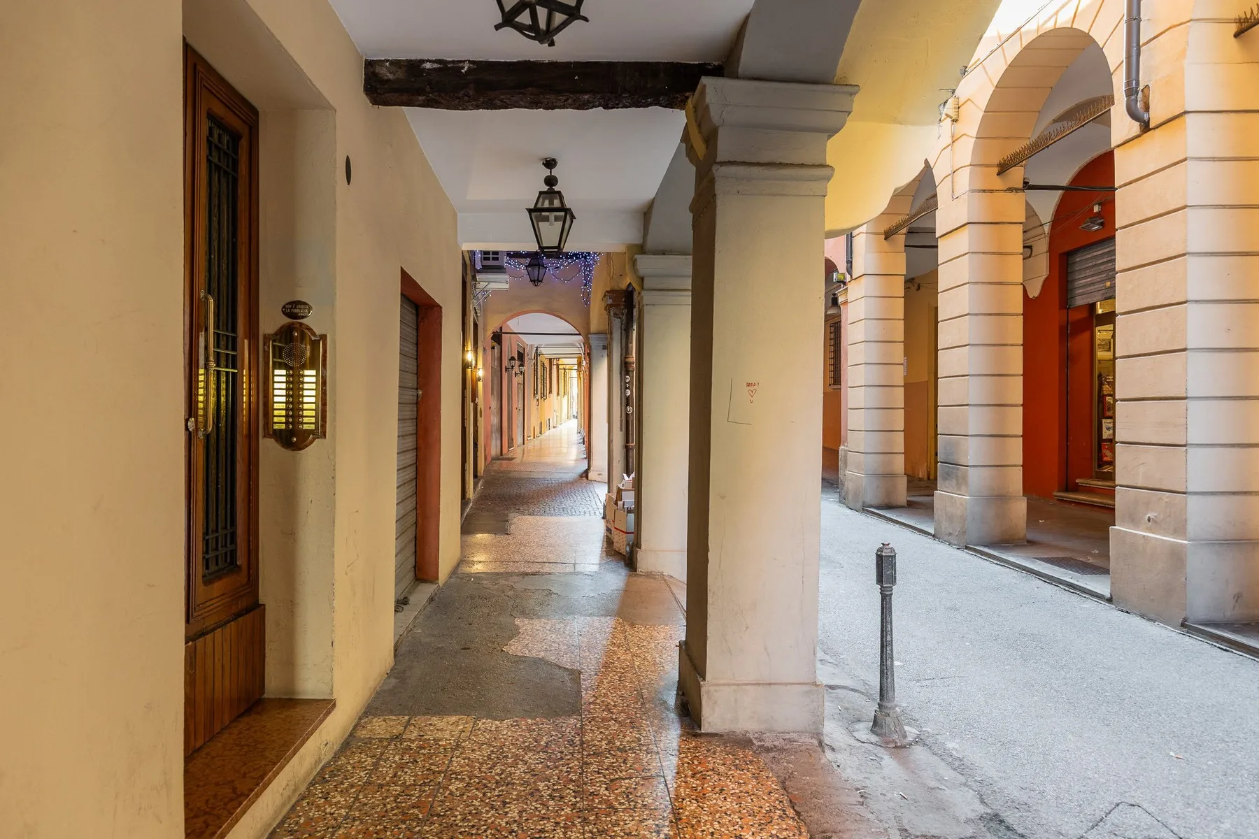 Un pasaje cubierto con suelo de piedra recorre junto a una arcada de calle.