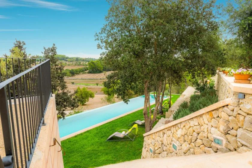 An outdoor pool and garden sit beside a stone terrace overlooking the countryside.