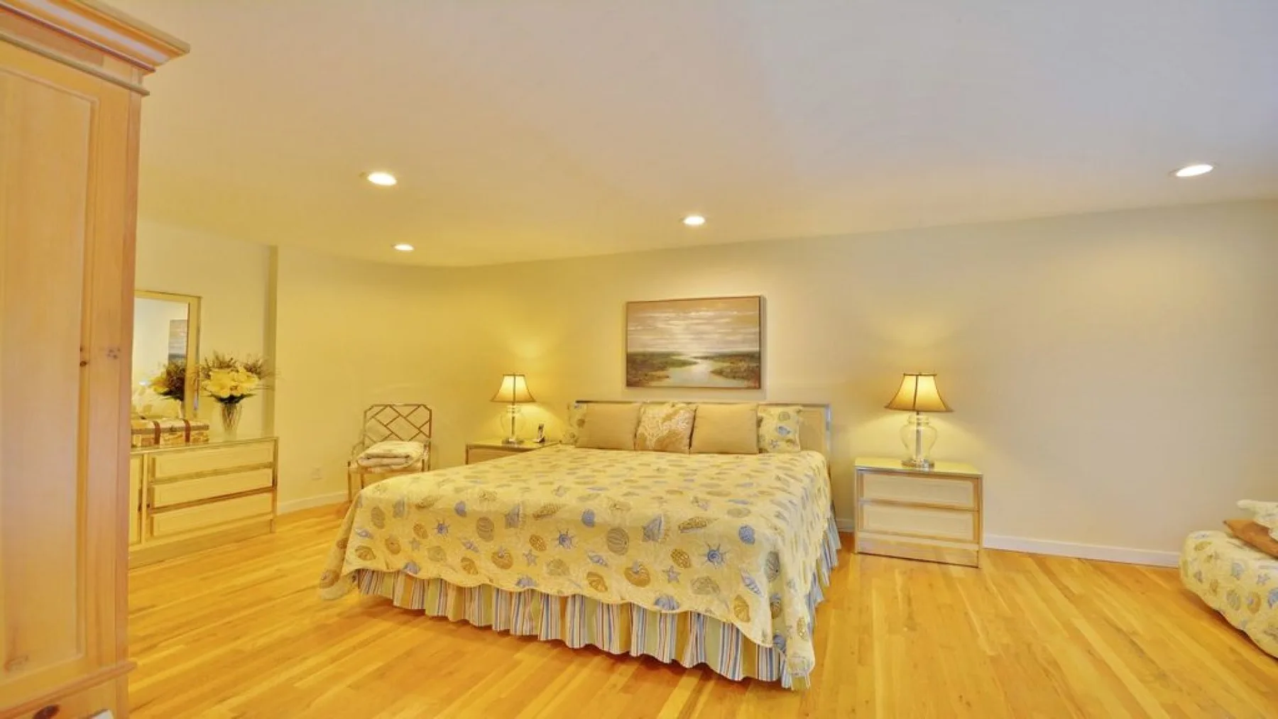 A warmly lit bedroom with a large bed and matching bedside tables.