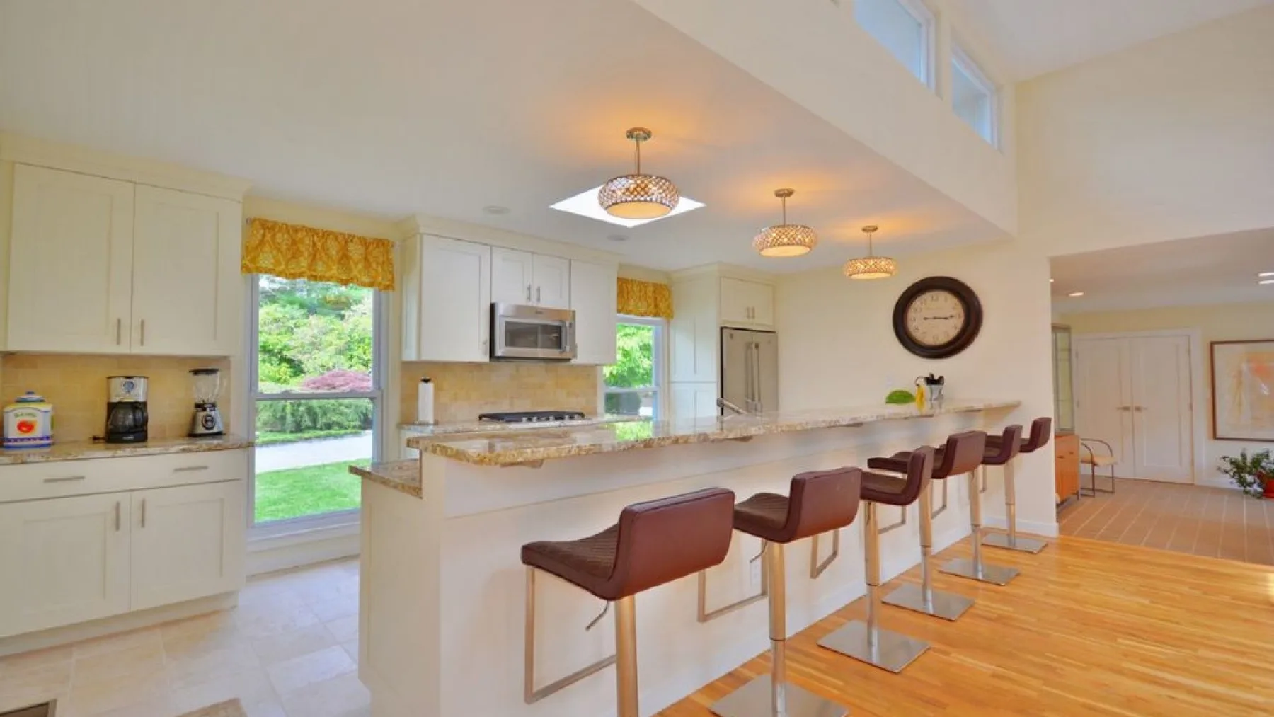 A bright open kitchen with a long counter and seating.