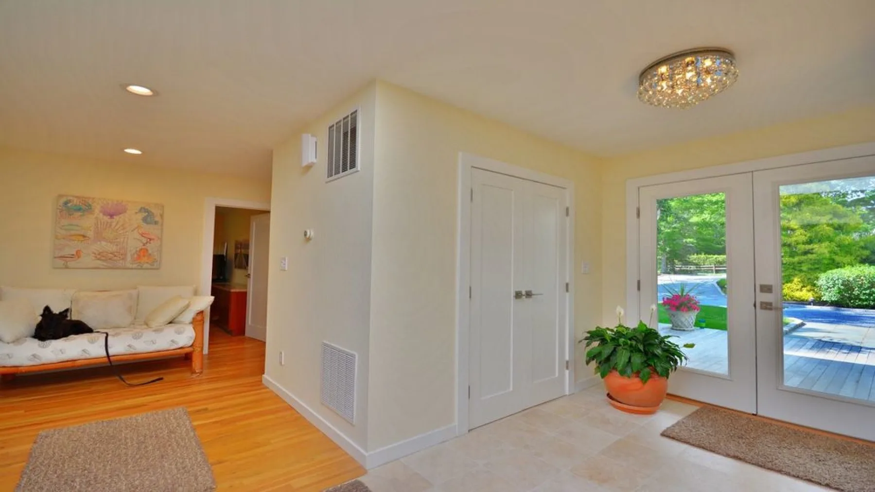 A bright living room opens onto a patio through glass doors.