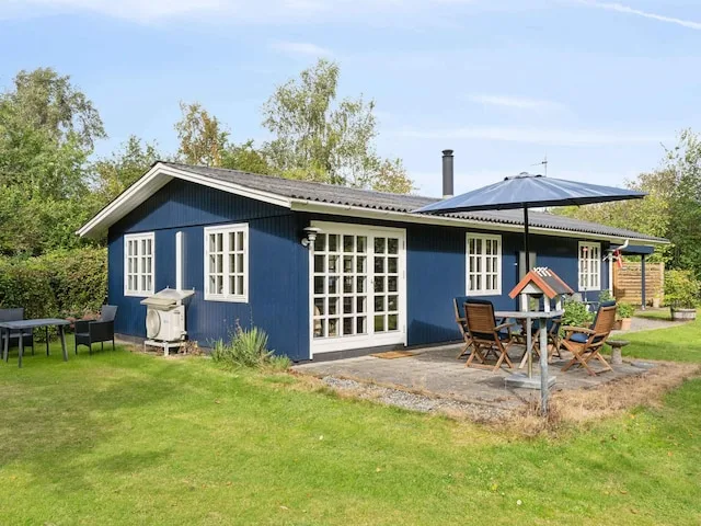 A blue vacation house with a paved patio and outdoor seating.