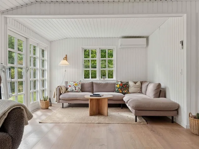 A bright living room with sectional seating and large windows.