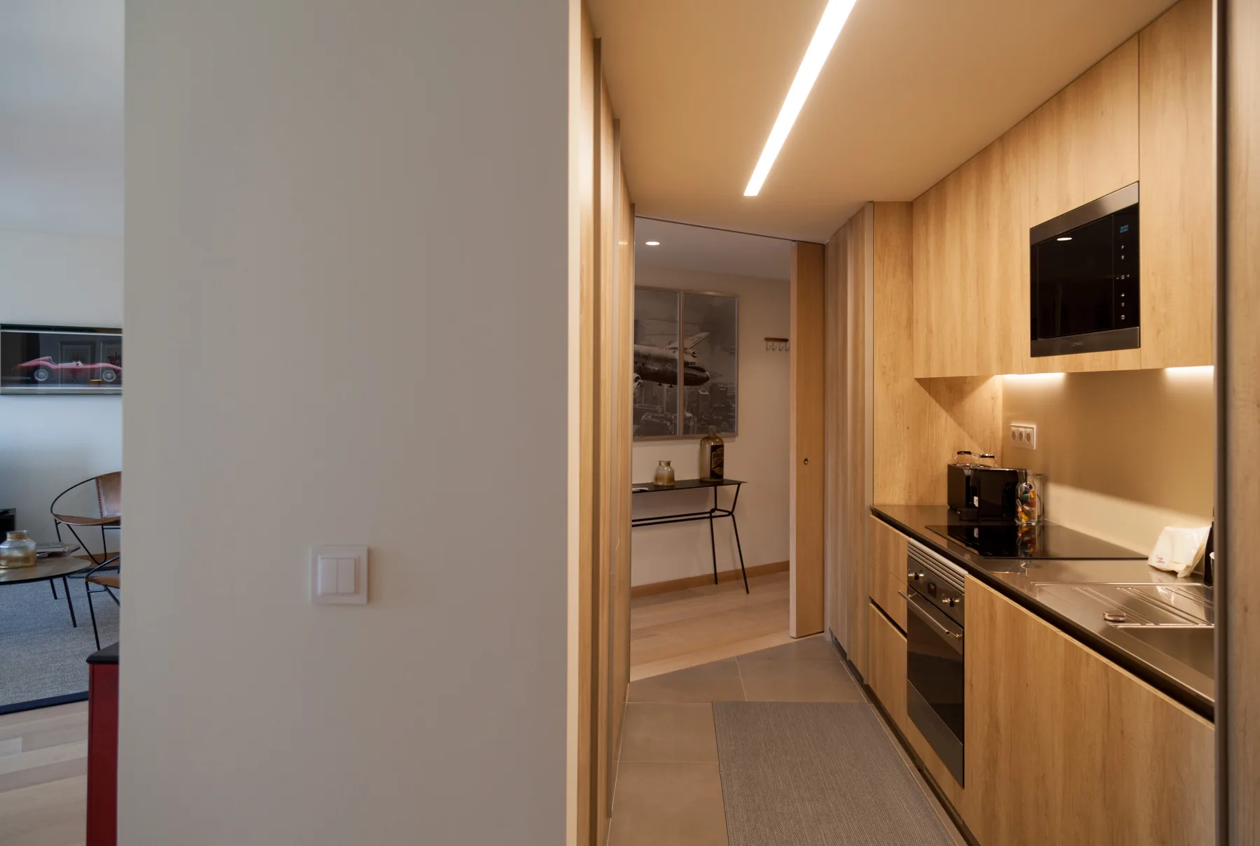 Una cocina moderna con gabinetes de madera y una encimera larga.