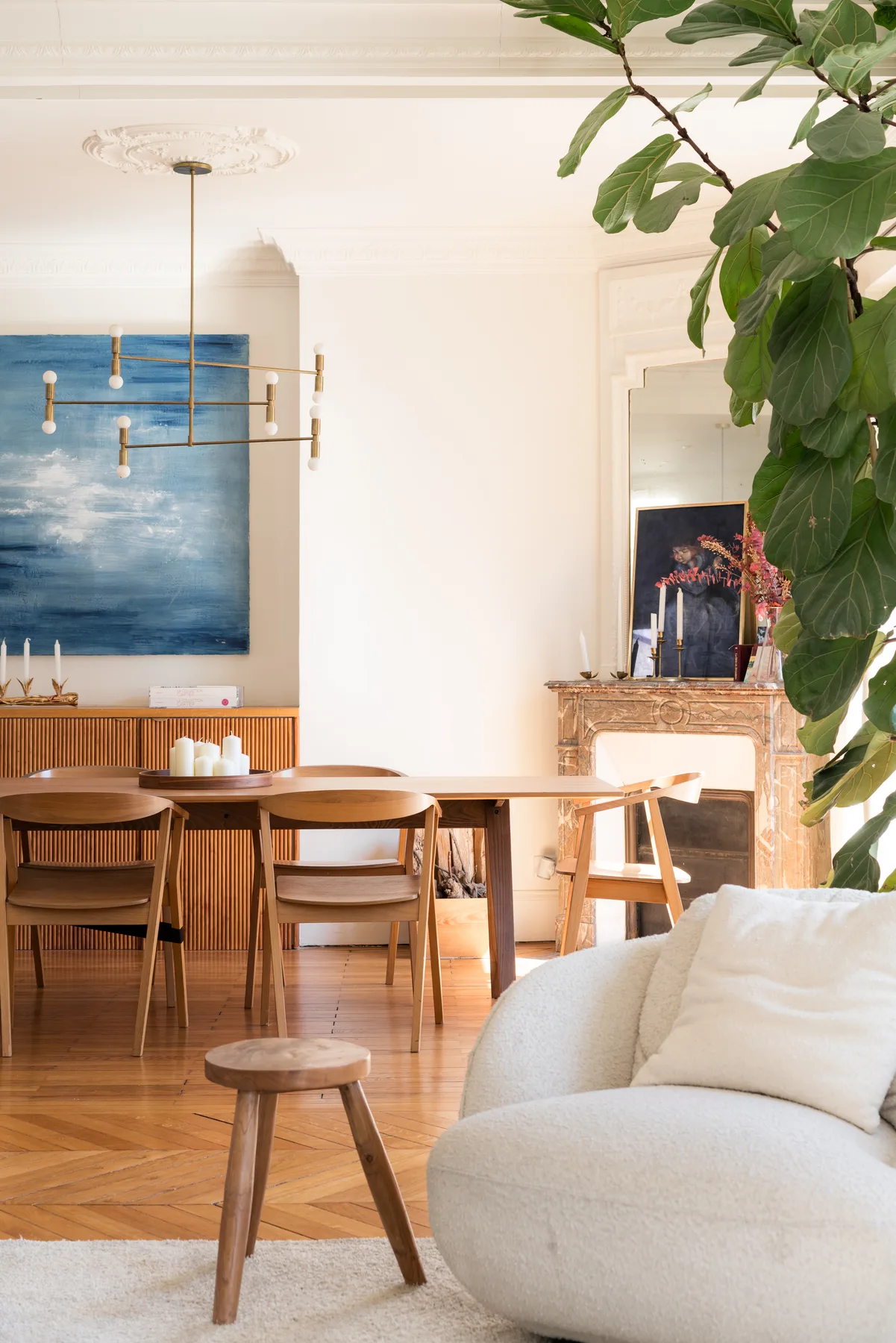 A bright living and dining room with a dining table and a white sofa.