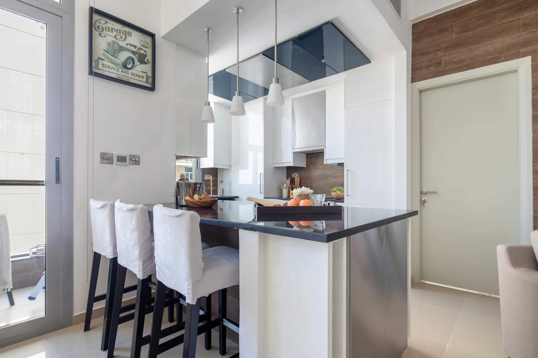 A bright kitchen and dining area with a counter and white seating.
