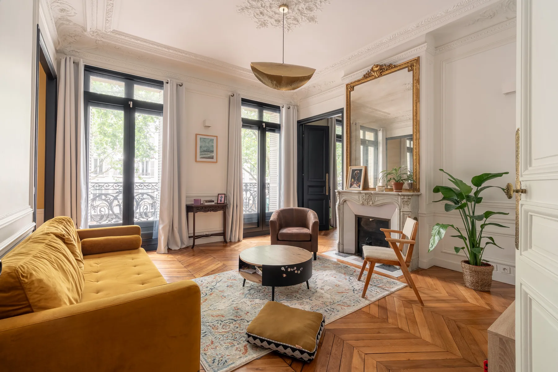 Una luminosa sala de estar con asientos alrededor de una mesa de centro y una chimenea.