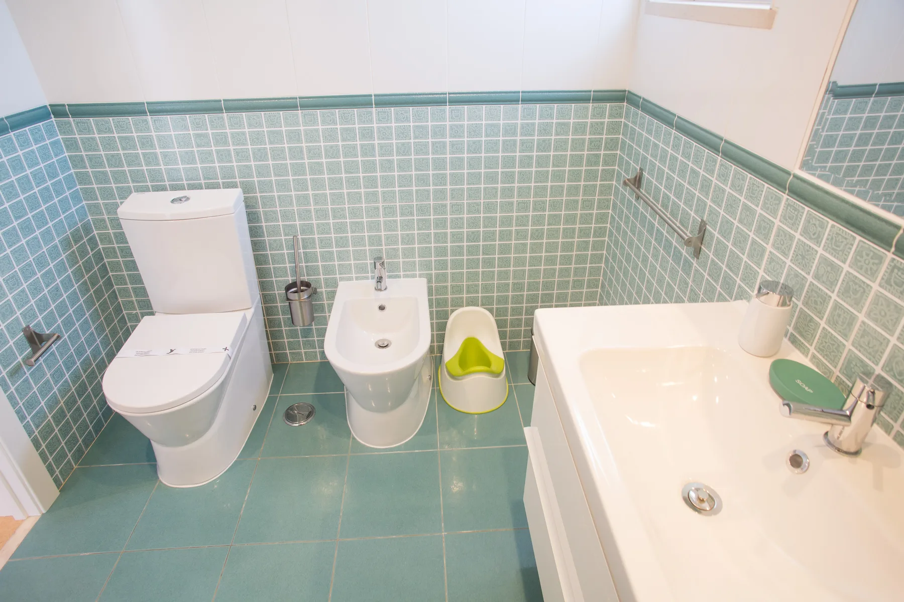 Un baño alicatado con inodoro, bidé y bañera.