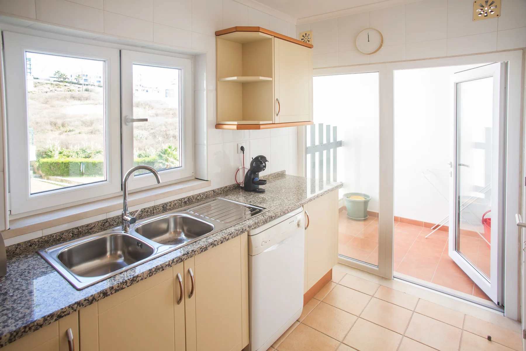 Cocina luminosa con una encimera y ventanas con vistas al exterior.