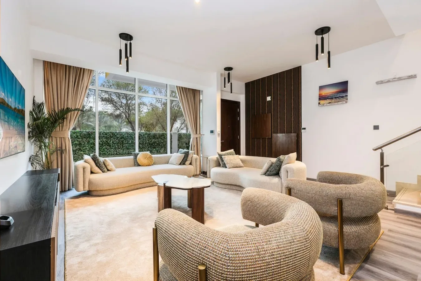 Una sala luminosa con asientos alrededor de una mesa de centro junto a grandes ventanas.