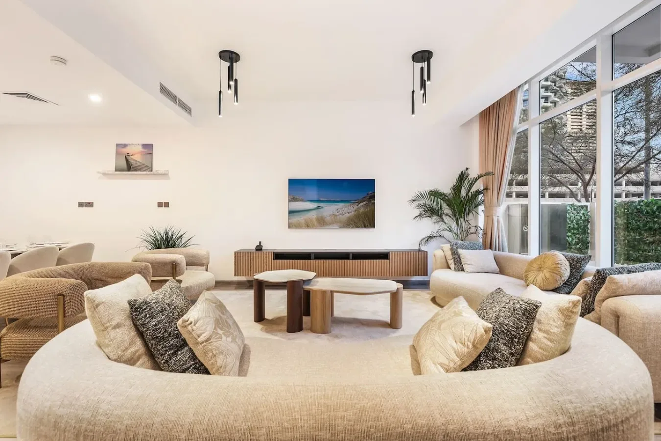 Una sala luminosa con asientos curvos, una mesa de centro baja y grandes ventanas.