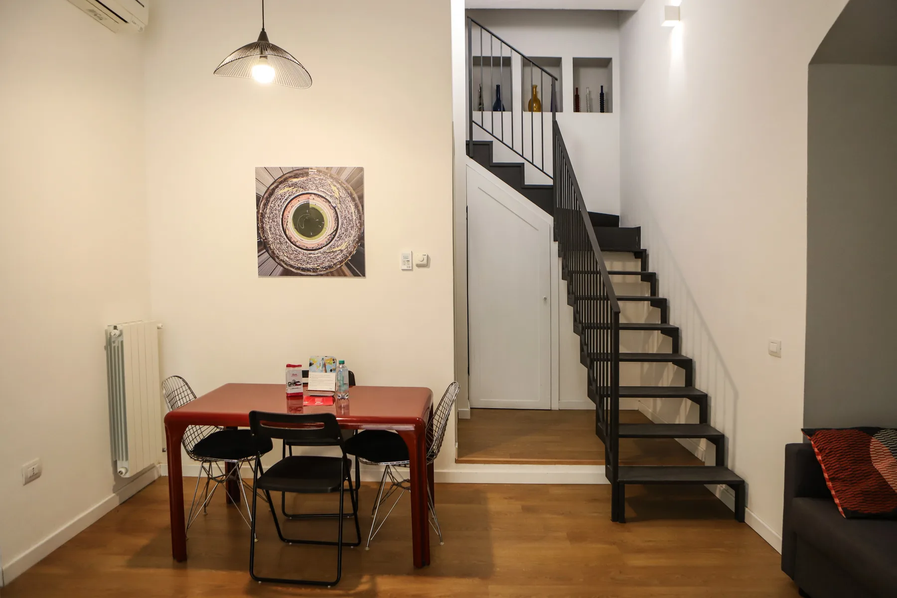 Comedor con una mesa y sillas junto a una escalera.