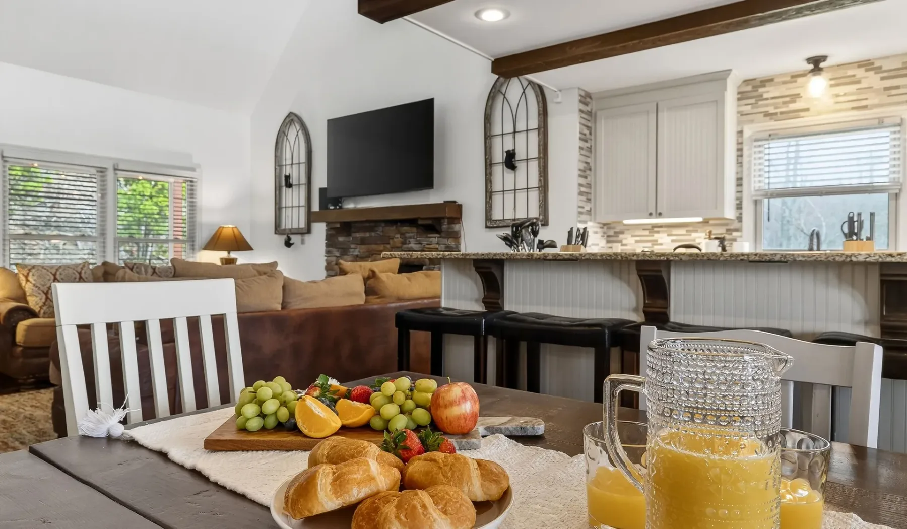 Un espacio abierto de sala y cocina con mesa de comedor y asientos.