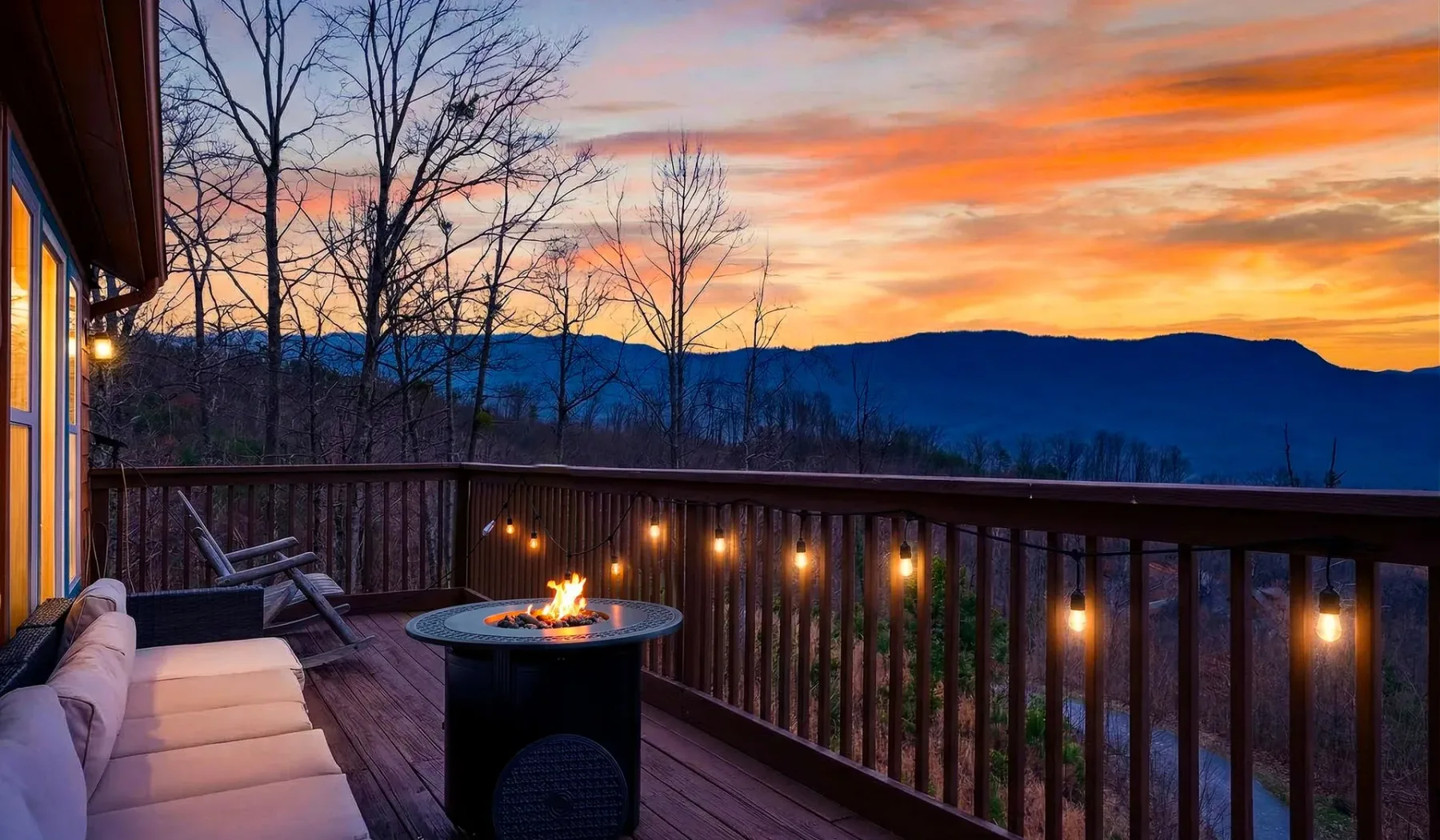 Una terraza da a las montañas al atardecer, con un brasero encendido en primer plano.