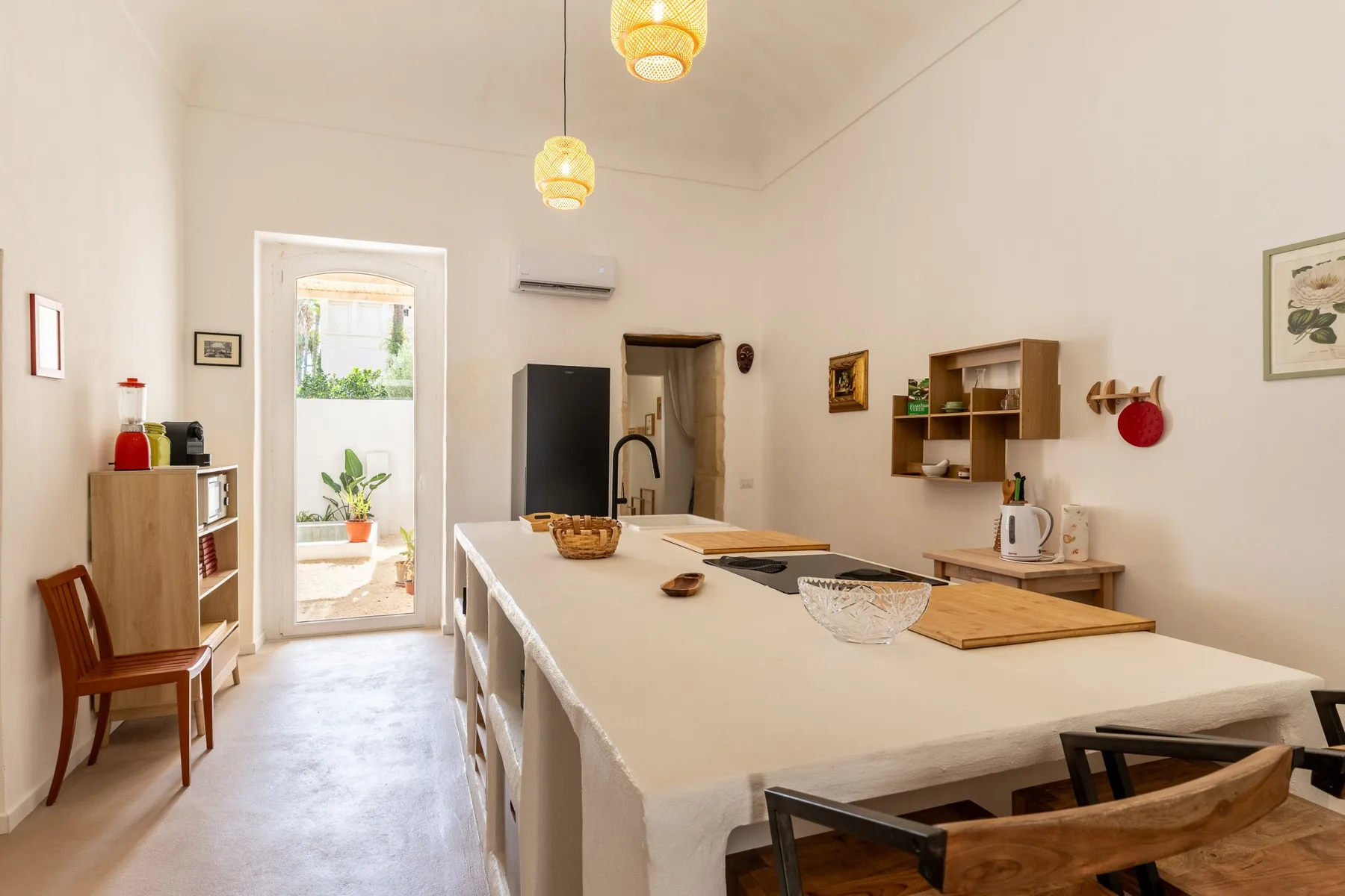 A bright kitchen with a long island, sink, and dining seating.