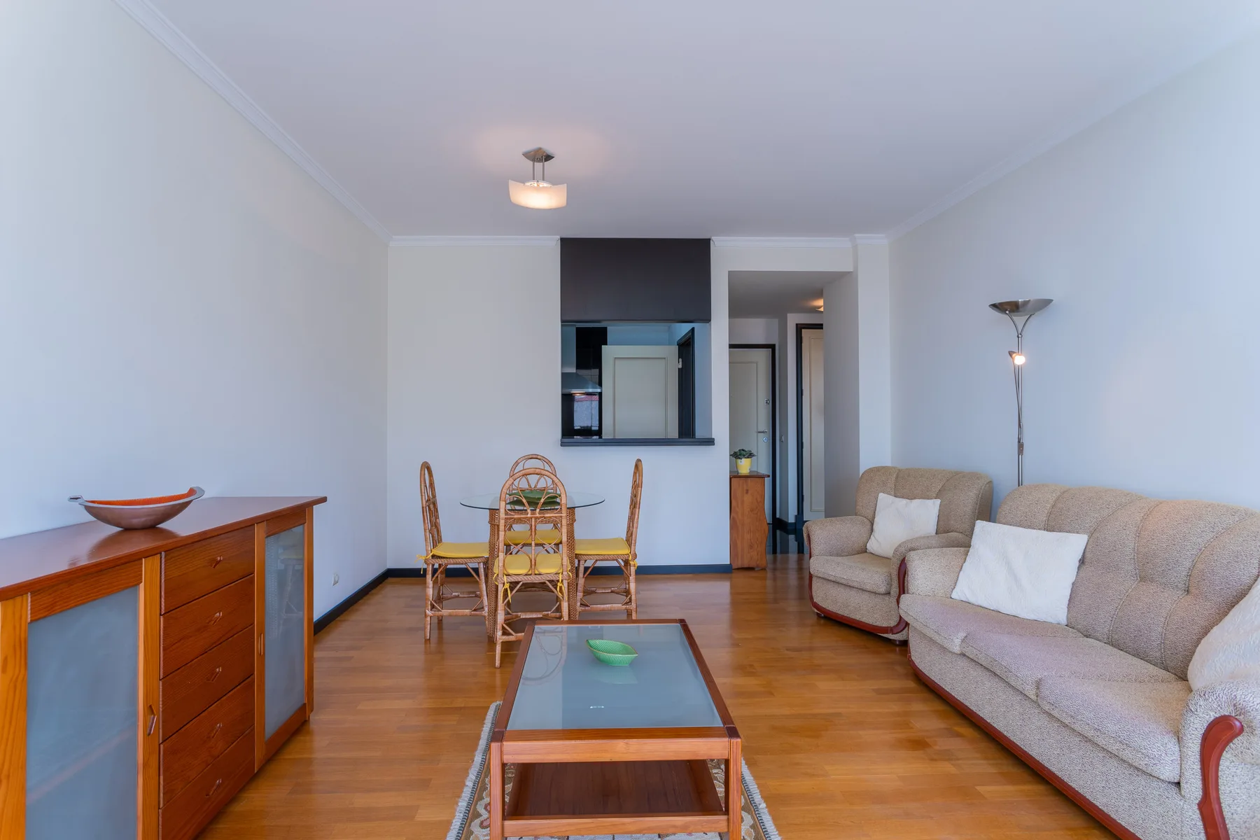 Living room with seating, a dining table, and a wooden floor.
