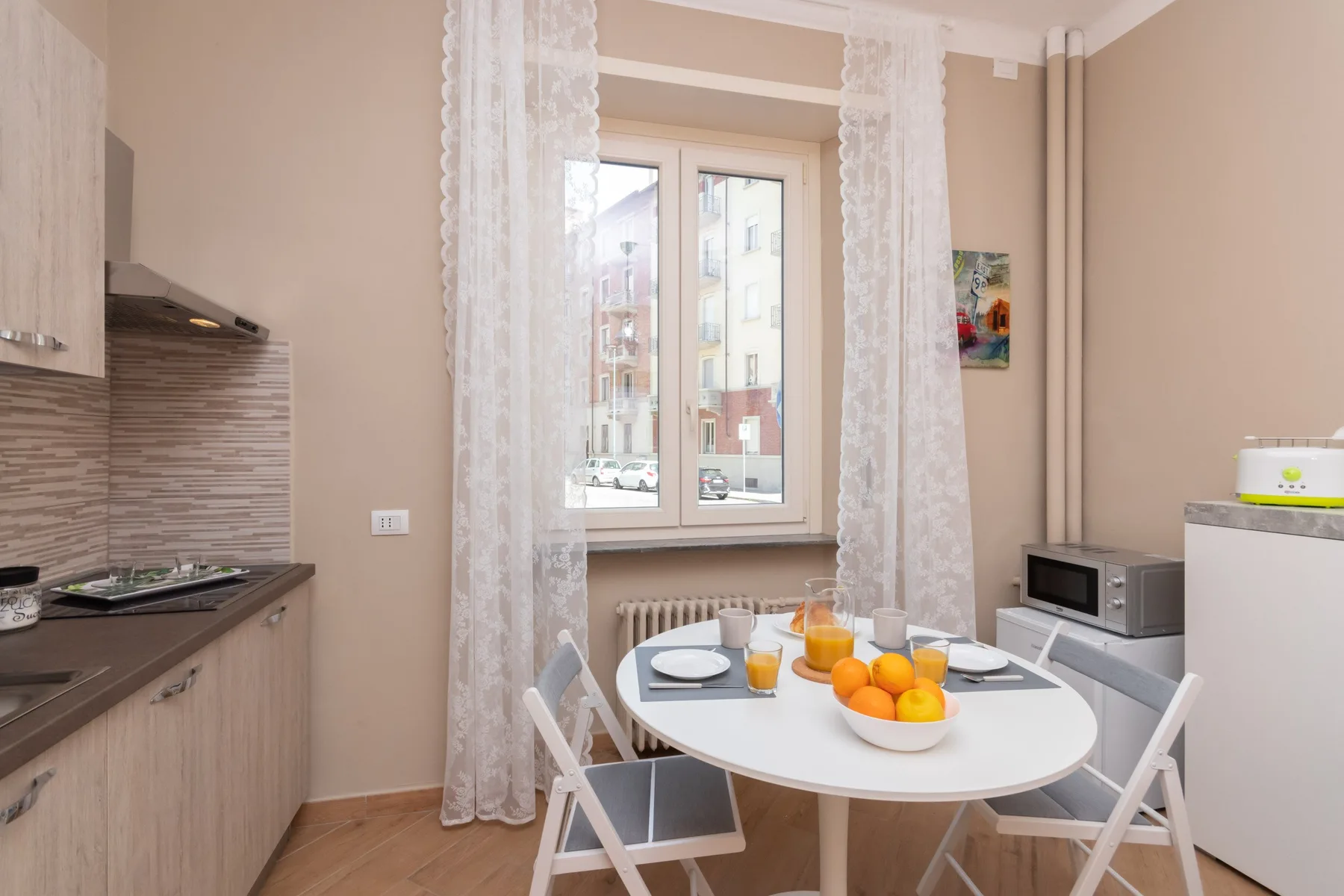 A bright kitchen and dining area with a round table beside a window.