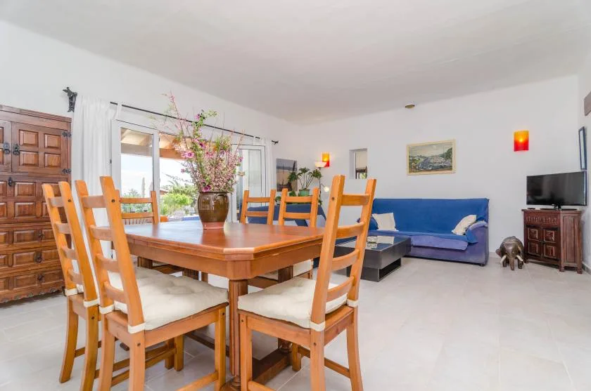Un comedor con una mesa de madera y asientos junto a un sofá azul.