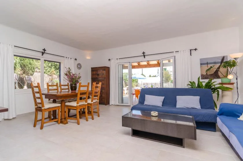 Una sala luminosa con zona de comedor junto a las puertas del patio.
